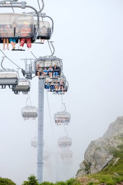 Krasnaya Polyana. Rusya. 28 Temmuz 2019: Dağ zirvelerine teleferik ile tırmanan turistler.