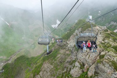 Krasnaya Polyana. Rusya. 28 Temmuz 2019: Dağ zirvelerine teleferik ile tırmanan turistler.