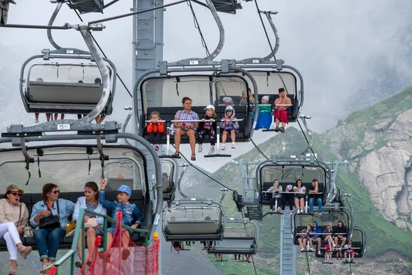 Krasnaya Polyana. Rusia. 28 iulie 2019: Turiștii urcând pe vârfurile muntelui cu telecabina . — Fotografie, imagine de stoc