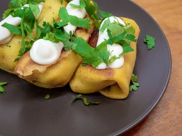 Et ile doldurulmuş ve beyaz sos ile terbiyeli ve kahverengi bir tabak üzerine maydanoz yaprakları serpilir iştah açıcı krep.