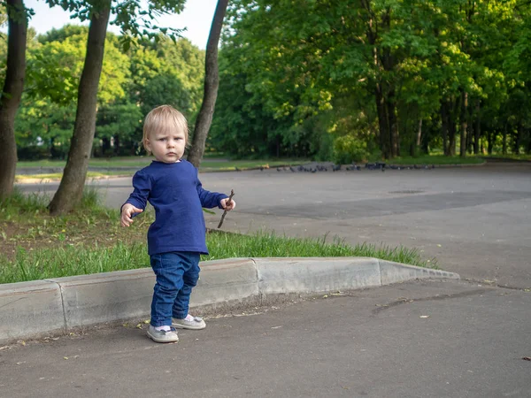 Emotionales Porträt eines genervten kleinen blonden Mädchens an einem Sommertag in einem Stadtpark. schönes kapriziöses Kind. — Stockfoto