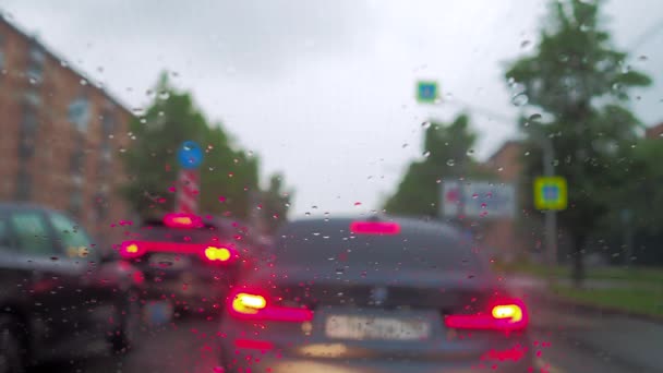 Selektivt Fokus Regndroppar Vindrutan Bil Som Står Trafikstockning Stadsgata Små — Stockvideo