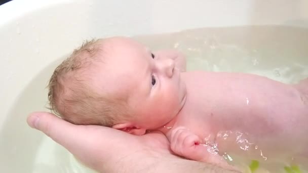 Baden Eines Neugeborenen Mädchens Der Vater Hält Das Baby Sanft — Stockvideo