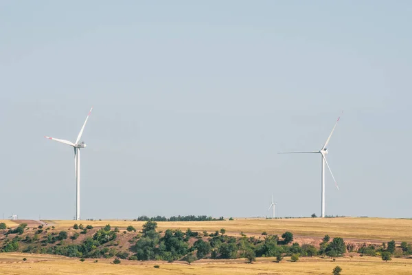 Turbinas eólicas en un paisaje árido. Una forma alternativa de generar electricidad — Foto de Stock
