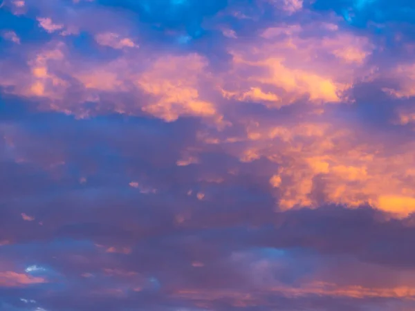 A colorful sky full of pink, blue and orange colors. Contrasting clouds shimmering in different colors at sunset, illuminated by the setting sun. Bright saturated natural background — Stock Photo, Image
