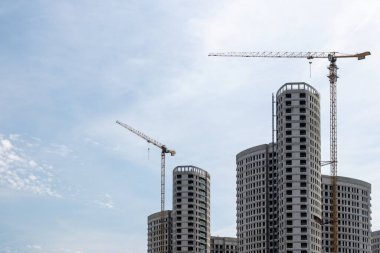 Moskova. - Rusya. 06 Eylül 2020 'de gökyüzünün arka planına karşı modern bir monolitik ev inşaatının görüntüsü. Yüksek katlı bir apartmanın inşaatında kule vinçleri