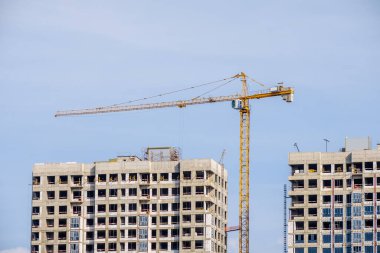 Moskova. - Rusya. 06 Eylül 2020 'de gökyüzünün arka planına karşı modern bir monolitik ev inşaatının görüntüsü. Yüksek katlı bir apartmanın inşaatında kule vinçleri