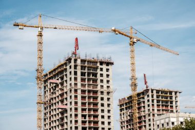 Moskova. - Rusya. 06 Eylül 2020 'de gökyüzünün arka planına karşı modern bir monolitik ev inşaatının görüntüsü. Yüksek katlı bir apartmanın inşaatında kule vinçleri