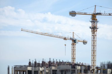 Moskova. - Rusya. 06 Eylül 2020 'de gökyüzünün arka planına karşı monolitik bir ev inşa edilişi. Kule vinci ve üniformalı işçiler güçlendiren çelik bir yapı oluşturuyorlar.