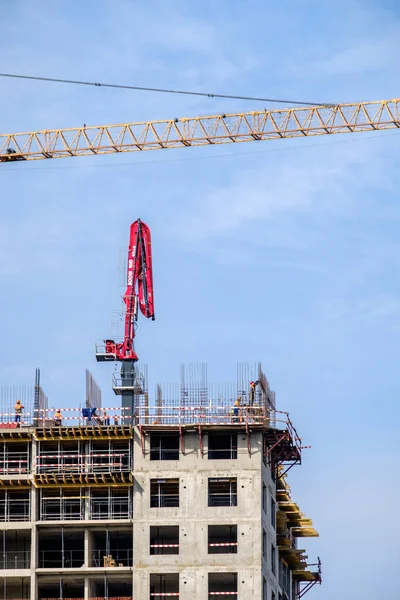 Moscow. Russia. September 06, 2020 View of the construction of a monolithic house against the background of the sky. A tower crane and uniformed workers assembling a reinforcing steel structure — Stock Image Moscow. Russia. September 06, 2020 View of the construction of a monolithic house against the background of the sky. A tower crane and uniformed workers assembling a reinforcing steel structure Royalty Free Stock Photos