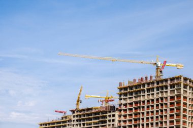 Moskova. - Rusya. 06 Eylül 2020 'de gökyüzünün arka planına karşı modern bir monolitik ev inşaatının görüntüsü. Yüksek katlı bir apartmanın inşaatında kule vinçleri