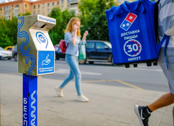 Moskau. Russland. 04. September 2020 Ein Gerät zur Desinfektion der Hände an einer Haltestelle im Hintergrund von Fußgängern und Straßen mit Fahrzeugen. Moderne Technologien zum Schutz der Menschen — Stockfoto