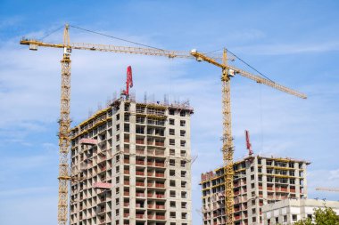 Moskova. - Rusya. 06 Eylül 2020 'de gökyüzünün arka planına karşı modern bir monolitik ev inşaatının görüntüsü. Yüksek katlı bir apartmanın inşaatında kule vinçleri