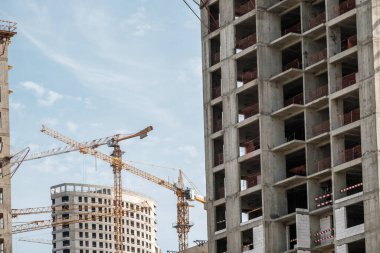 Moskova. - Rusya. 06 Eylül 2020 'de gökyüzünün arka planına karşı modern bir monolitik ev inşaatının görüntüsü. Yüksek katlı bir apartmanın inşaatında kule vinçleri