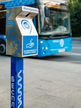 Moskova. - Rusya. 4 Eylül 2020 mavi bir otobüsün önündeki toplu taşıma durağında el dezenfeksiyonu için kullanılan bir cihaz. İnsanları enfeksiyondan koruyan modern teknolojiler