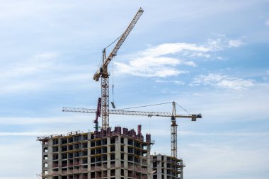 Moskova. - Rusya. 06 Eylül 2020 'de gökyüzünün arka planına karşı modern bir monolitik ev inşaatının görüntüsü. Yüksek katlı bir apartmanın inşaatında kule vinçleri