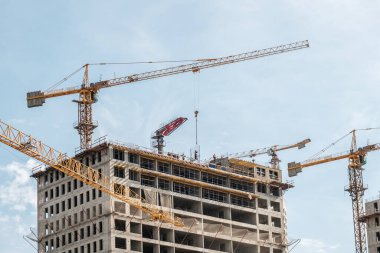 Moskova. - Rusya. 06 Eylül 2020 'de gökyüzünün arka planına karşı monolitik bir ev inşa edilişi. Kule vinci ve üniformalı işçiler güçlendiren çelik bir yapı oluşturuyorlar..