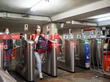Moskova. - Rusya. 22 Eylül 2020. Yolcular Moskova metro istasyonundaki otomatik turnikelerden geçiyorlar. İnsanların yüzlerinde enfeksiyonlara karşı koruyucu maskeler ve viral enfeksiyonların yayılması