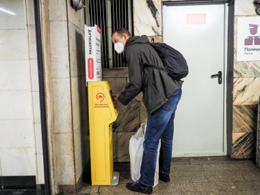 Moskova. - Rusya. 22 Eylül 2020. Bir yolcu Moskova metro istasyonunda antiseptikle ellerini özel bir otomatikle tedavi ediyor. Viral enfeksiyonların yayılmasını önlemek için devlet tedbirleri.
