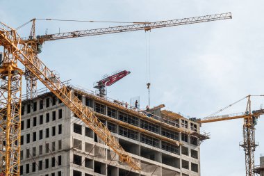 Moskova. - Rusya. 06 Eylül 2020 'de gökyüzünün arka planına karşı monolitik bir ev inşa edilişi. Kule vinci ve üniformalı işçiler güçlendiren çelik bir yapı oluşturuyorlar..