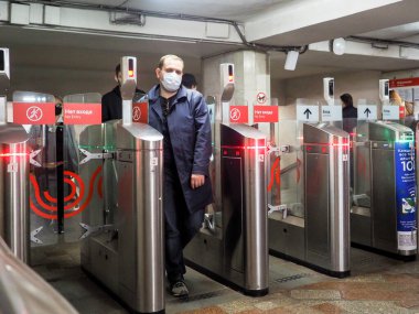 Moskova. - Rusya. 22 Eylül 2020. Yolcular Moskova metro istasyonundaki otomatik turnikelerden geçiyorlar. İnsanların yüzlerinde enfeksiyonlara karşı koruyucu maskeler ve viral enfeksiyonların yayılması