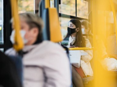 Moskova. - Rusya. 24 Eylül 2020. Şehir otobüsündeki koruyucu maskeli genç bir kıza odaklan. Viral enfeksiyon önleme önlemleri. Toplu taşımacılıkta sosyal uzaklık.