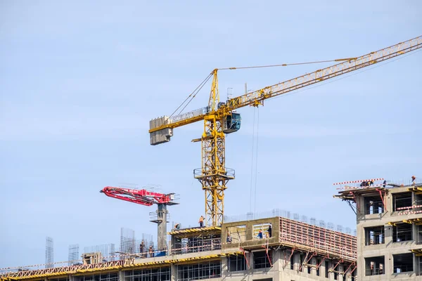 Moscow. Russia. September 06, 2020 View of the construction of a monolithic house against the background of the sky. A tower crane and uniformed workers assembling a reinforcing steel structure. — Stock Image Moscow Russia September 2020 View Construction Monolithic House Background Sky Stock Image