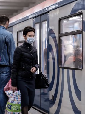 Moskova. - Rusya. 28 Eylül 2020. Koruyucu tıbbi maske takan genç bir kadın metro istasyonunda trene binmek için bekliyor. Koronavirüs salgınının ikinci dalgası..