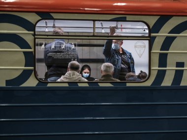 Moskova. - Rusya. 28 Eylül 2020. Metro vagonunda bir adam. Yolcunun yüzünde koruyucu bir tıbbi maske var. Viral enfeksiyonlar için önleyici önlemler. Koronavirüsün ikinci dalgası.