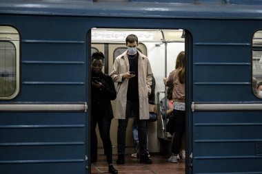 Moskova. - Rusya. 25 Eylül 2020 'de metro vagonunda bir adam akıllı telefonuna hevesle bakıyor. Yolcunun yüzünde koruyucu bir tıbbi maske var. Koronavirüsün ikinci dalgası.