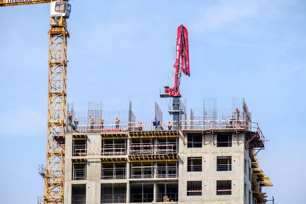 Moscow. Russia. September 06, 2020 View of the construction of a monolithic house against the background of the sky. A tower crane and uniformed workers assembling a reinforcing steel structure. — Stock Image Moscow Russia September 2020 View Construction Monolithic House Background Sky Stock Picture