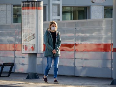 Moskova. - Rusya. 4 Ekim 2020 Koruyucu tıbbi maske takan genç bir kadın metro platformunda duruyor.