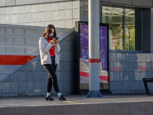 В Москве. Россия. 4 октября 2020 г. Девушка в защитной маске стоит на платформе станции метро — стоковое фото