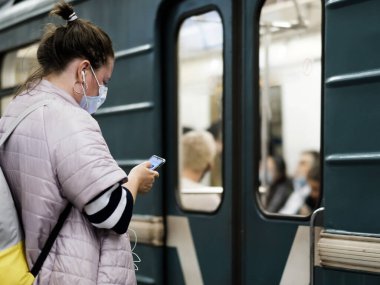 Moskova. - Rusya. 25 Eylül 2020 Koruyucu maskeli genç bir kız metro istasyonunda duruyor.