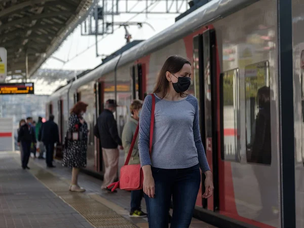 Moskau. Russland. 4. Oktober 2020 Eine junge Frau mit einer medizinischen Schutzmaske steht auf dem Bahnsteig einer U-Bahn — Stockfoto