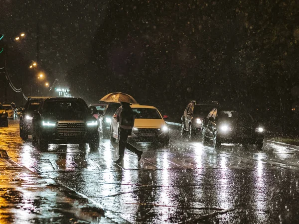 モスクワだ。ロシアだ。2020年9月17日。豪雨の中、夜市内を横断する歩行者の眺め. — ストック写真