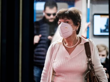 Moskova. - Rusya. 25 Eylül 2020. Yüzünde koruyucu maske olan genç bir kadın metro vagonunda duruyor..