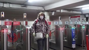 Moskova. - Rusya. 8 Ekim 2020. Tıbbi maskeli yolcular bir metro istasyonunda otomatik turnikelerden geçiyorlar..