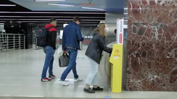 Moscow. Russia. October 5, 2020. A woman disinfects her hands in an automatic sanitizer on the subway. — Stock Video