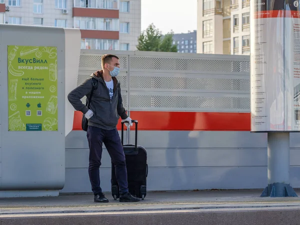 Moskau, Russland. 4. Oktober 2020. Ein einsamer Mann in Schutzmaske und Handschuhen mit einem Koffer am Bahnhof — Stockfoto