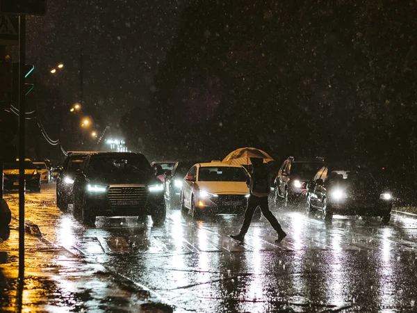 モスクワだ。ロシアだ。2020年9月17日。豪雨の中、夜市内を横断する歩行者の眺め. — ストック写真