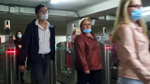 Moskva. Rusko. 8. října2020. Cestující v lékařských maskách procházejí automatickými turnikety na stanici metra. — Stock video
