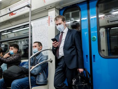 Moskova. - Rusya. 5 Ekim 2020 'de metro vagonunda bir adam telefonuna hevesle bakıyor.. 