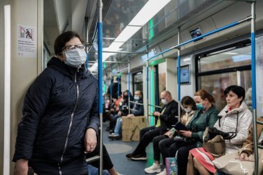 Moskova. - Rusya. 5 Ekim 2020. Yüzünde maskeyle metroda gözlüklü genç bir kadın.