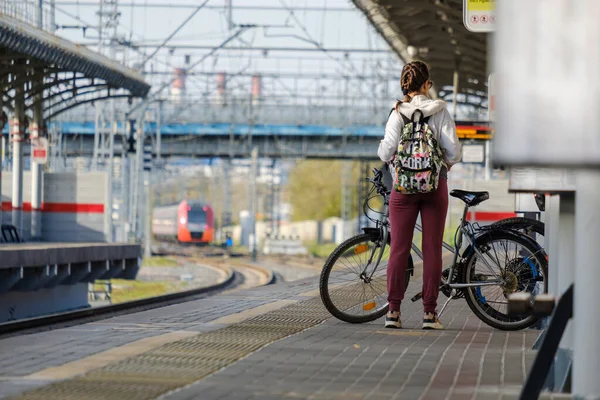 Moskau. Russland. 4. Oktober 2020 Ein junges Mädchen mit Fahrrad und Rucksack steht auf dem Bahnsteig eines Bahnhofs — Stockfoto