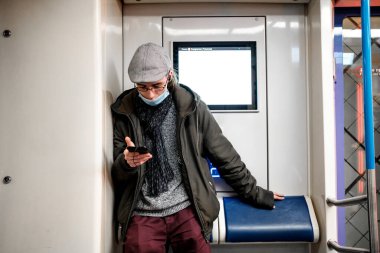 Moskova. - Rusya. 5 Ekim 2020 'de metro vagonunda bir adam telefonuna hevesle bakıyor.. 