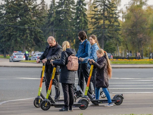 В Москве. Россия. 11 октября 2020 Родители и дочь наслаждаются электрическим скутером в солнечный осенний день. — стоковое фото