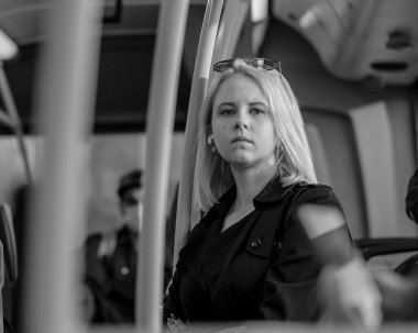 Moskova. - Rusya. 29 Eylül 2020. Düşünceli yüzlü güzel sarışın bir kız otobüsün kabininde duruyor. Toplu taşıma araçlarıyla şehri dolaşmak. Siyah beyaz fotoğraf.