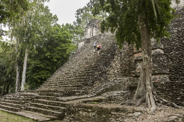 A couple climbs the steps of the Mayan temple of Dzibanche along the Mexico, Belize border.