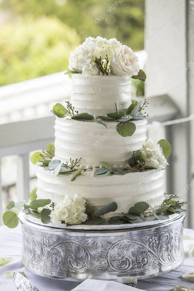 Three tiered wedding cake with buttercream icing and flowers